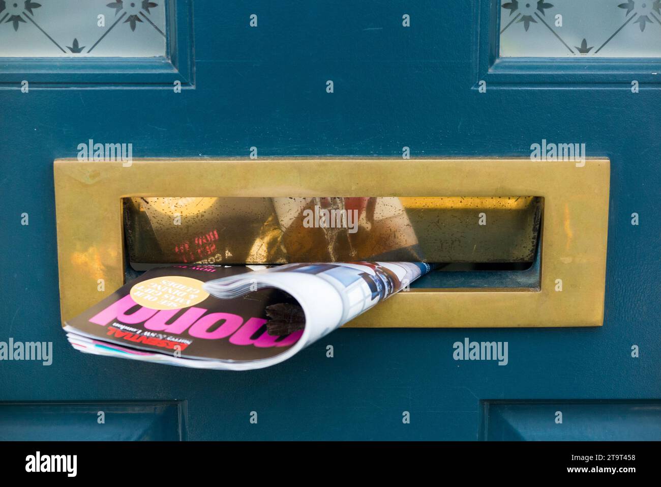Junk Mail Property 'Magazin' mit Immobilienmakler Werbung in einem Briefkasten, die Klappe offen halten, um Zugluft im Haus zu erzeugen und Wärme abzugeben. (136) Stockfoto