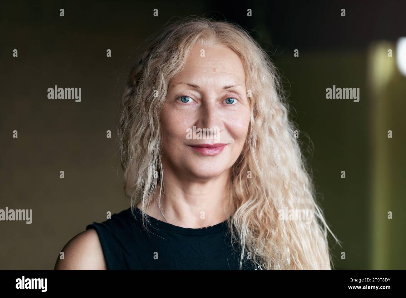Porträt einer zufriedenen blonden Frau mittleren Alters, die in die Kamera blickt Stockfoto