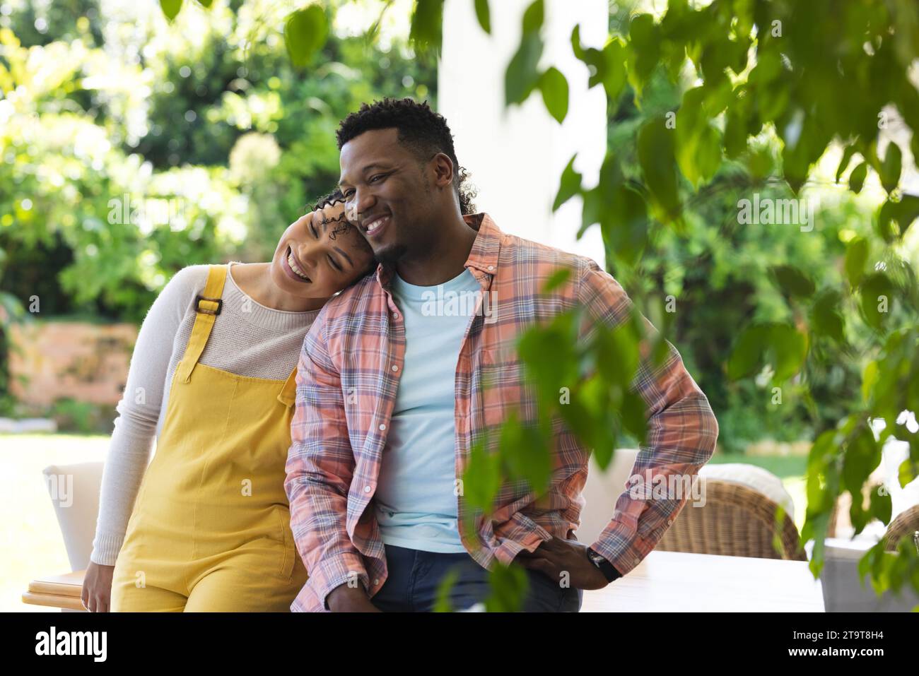 Glückliches afroamerikanisches Paar, das sich im sonnigen Garten umschließt, Kopierraum. Draußen, Ausdruck, Liebe, Zweisamkeit und Natur, unveränderlich. Stockfoto