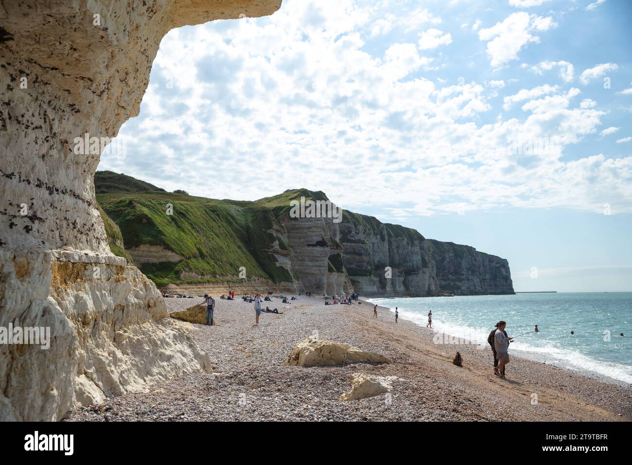 Etretat, Frankreich–September 2,2023: Touristen genießen Sonnenschein am Strand mit Klippen im Hintergrund Stockfoto