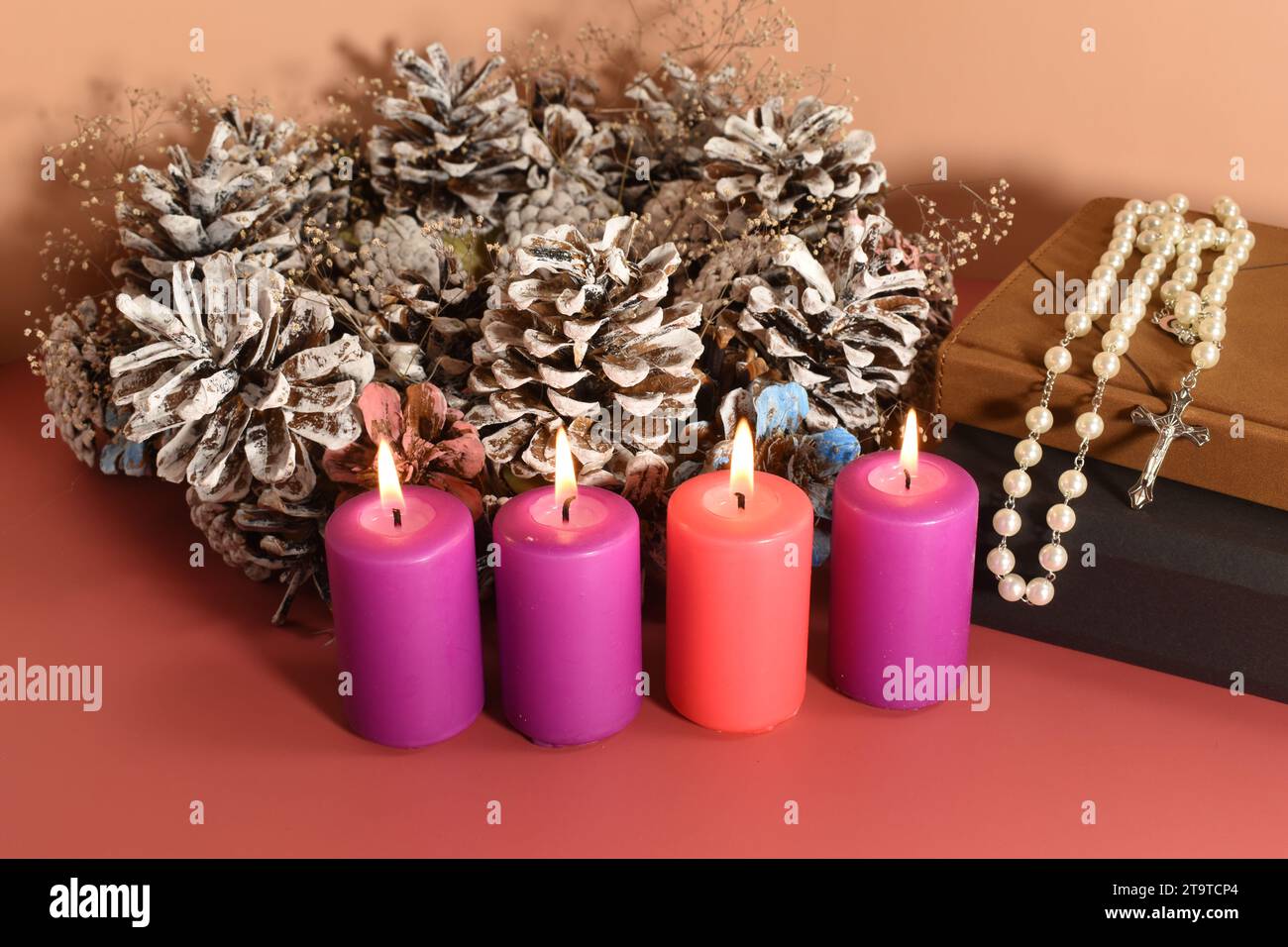 Vier Adventskerzen, Rosenkranz und Gebetsbücher. Adventskonzept. Stockfoto