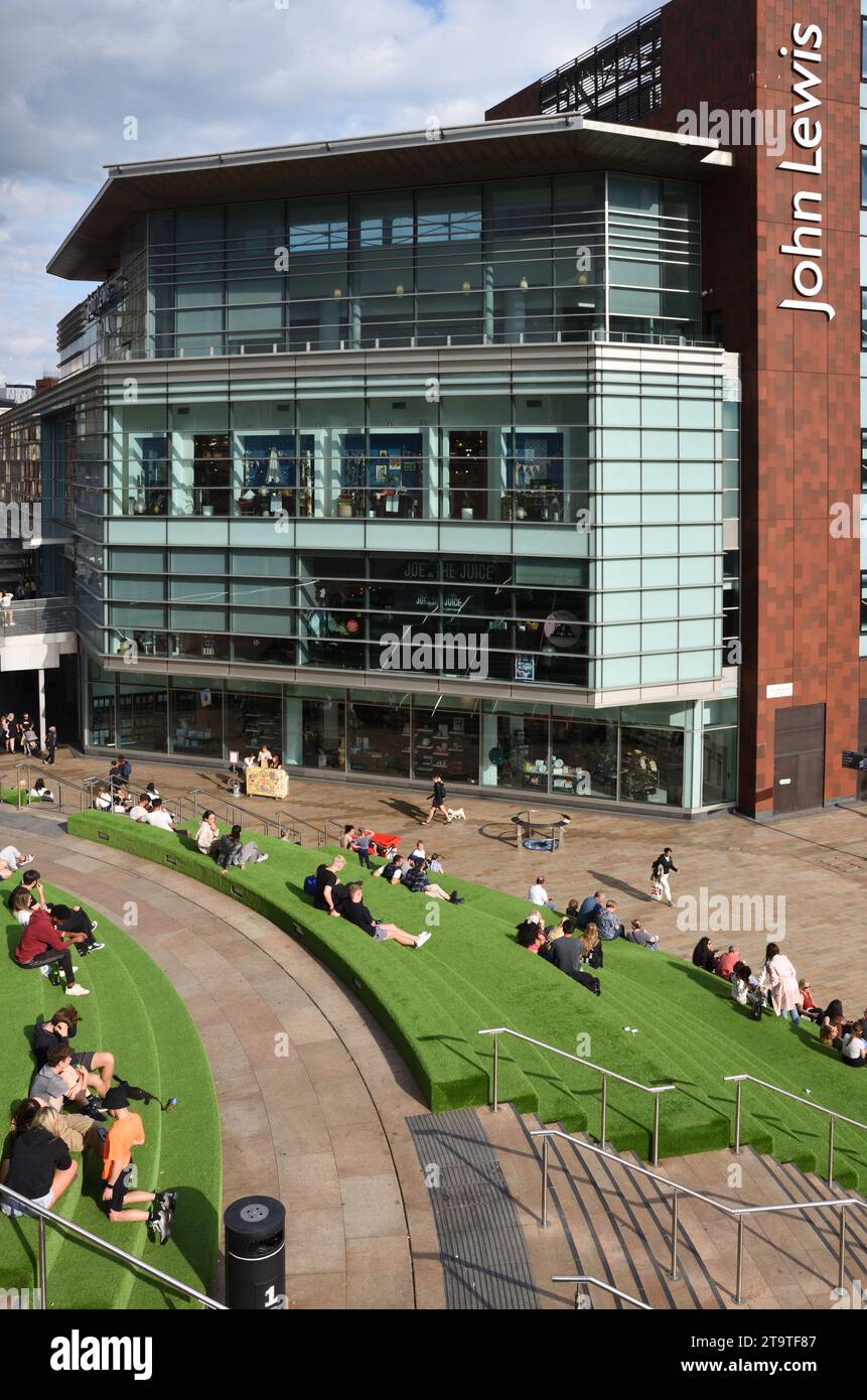 Shoppers Siiting auf Kunstrasen-Terrassen im Liverpool One City Centre Shopping Centre & dem modernen John Lewis Building Liverpool England UK Stockfoto
