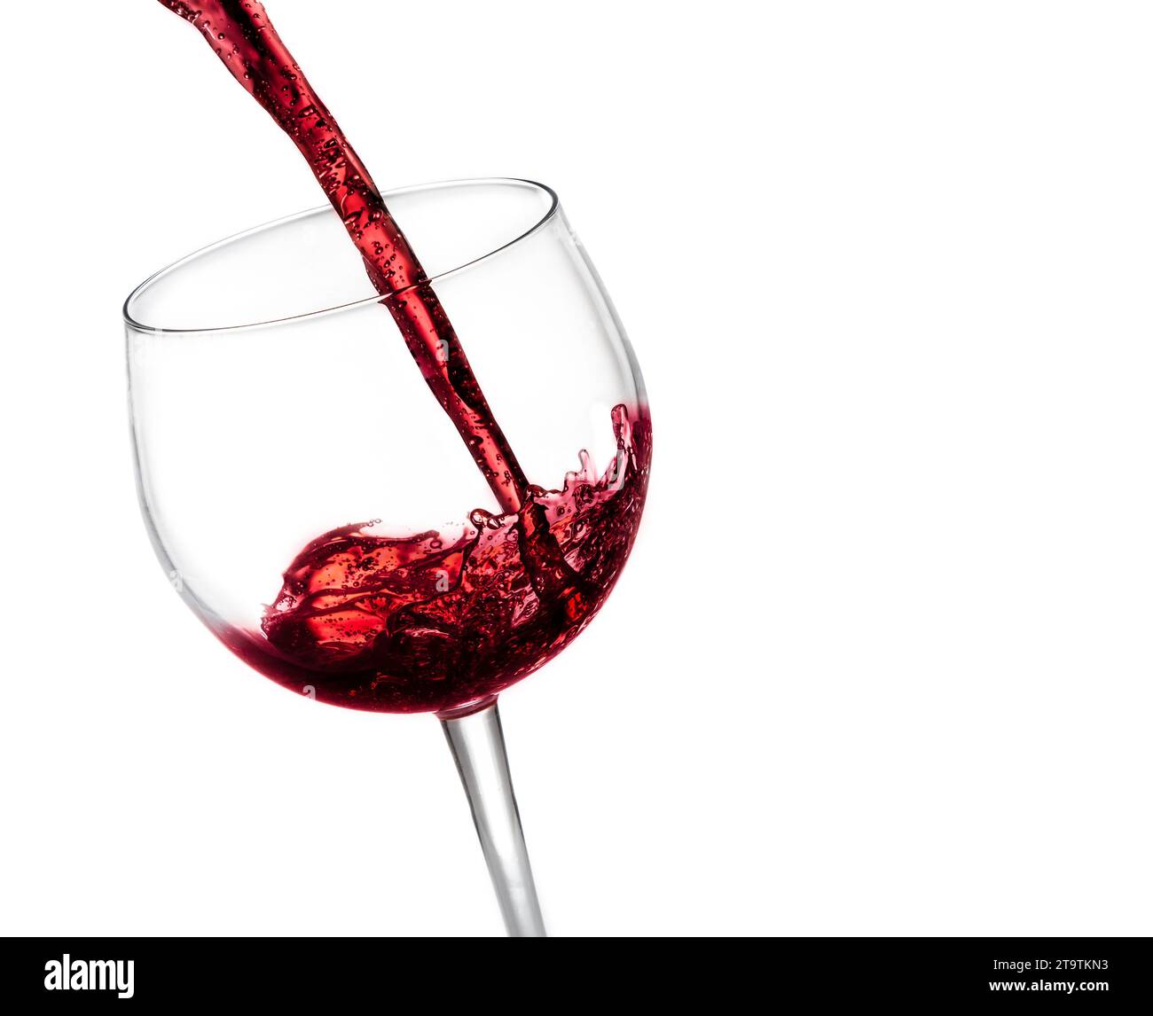 Rotwein in das Glas auf weißem Hintergrund gießen Stockfoto