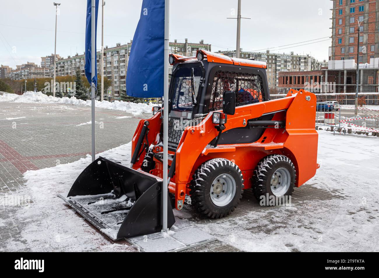 Kompaktlader auf einem Parkplatz in der Stadt an einem Wintertag Stockfoto
