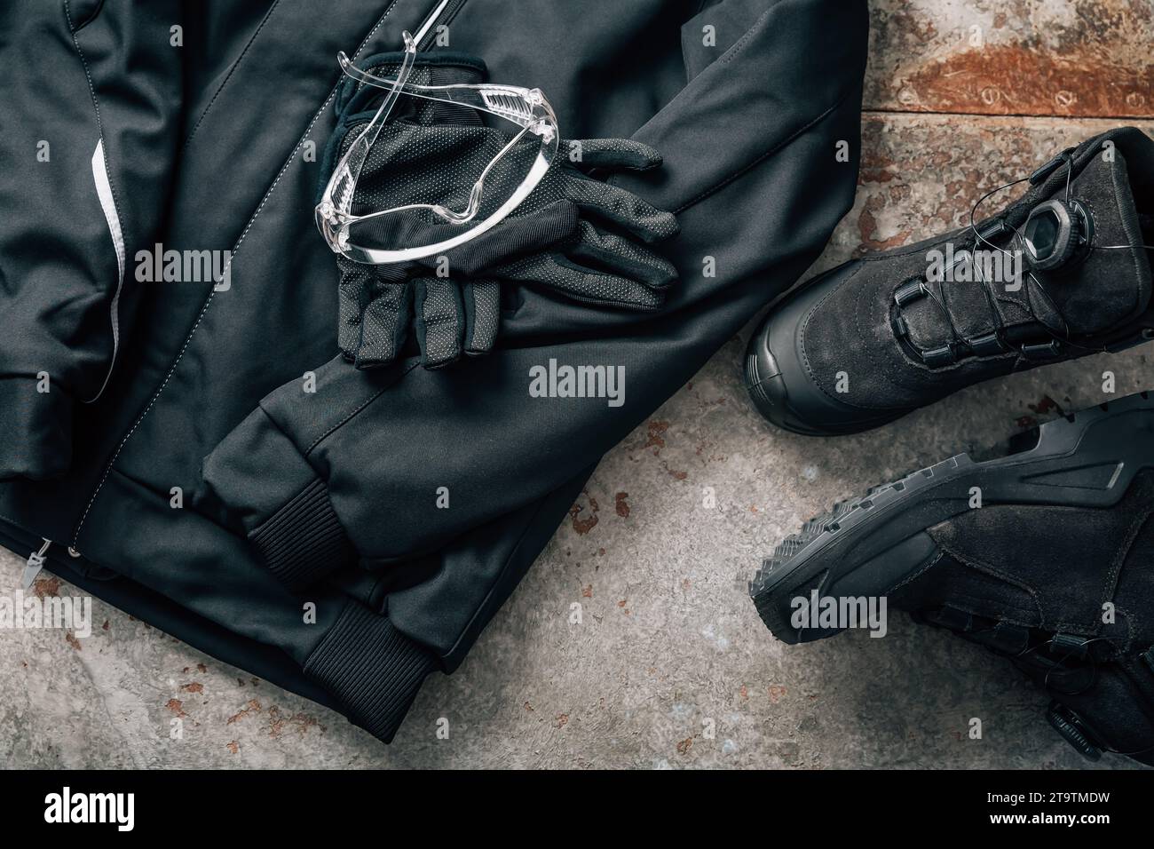 Arbeitskleidung für Handwerker mit Jacke, Sicherheitsschuhen, Handschuhen und Schutzbrille Stockfoto