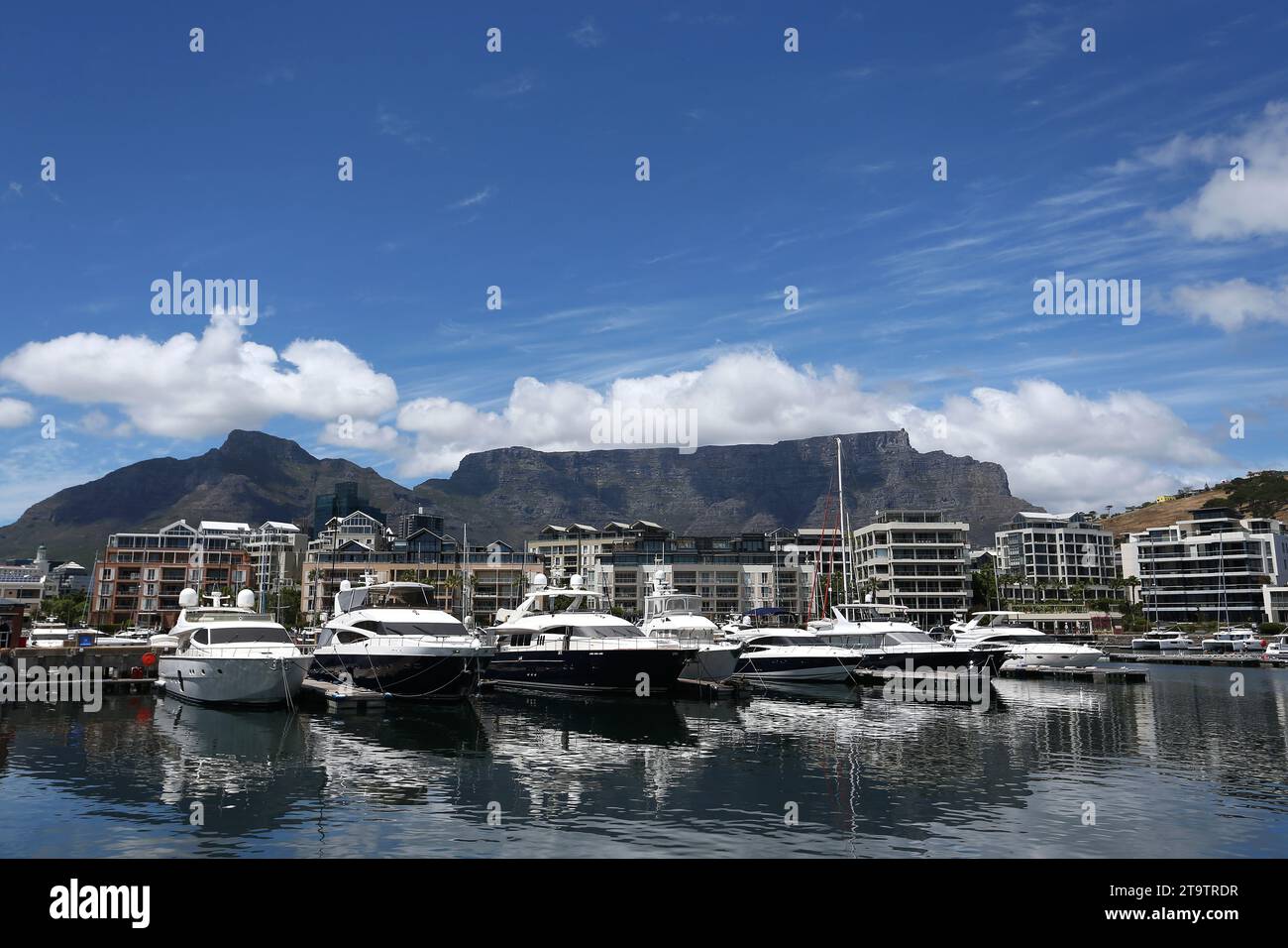 Ein allgemeiner Blick auf Luxusyachten, die mit weißen flauschigen Wolken vertäut sind und teilweise den wunderschönen Tafelberg in Kapstadt, Südafrika, bedecken Stockfoto