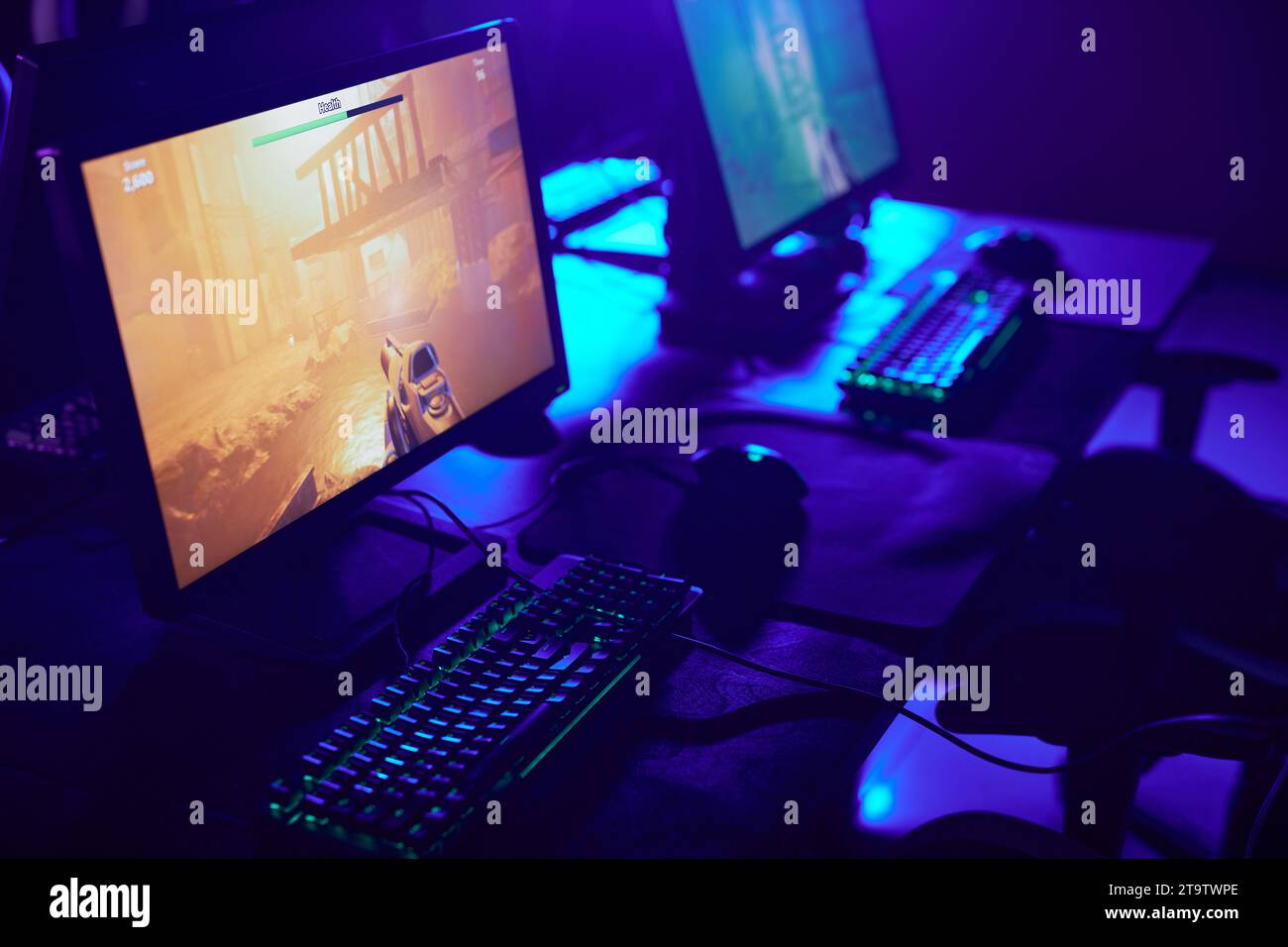 Hintergrundbild des Gaming-Setups mit Neonlichtern und Videospiel auf dem Computerbildschirm, Kopierraum Stockfoto