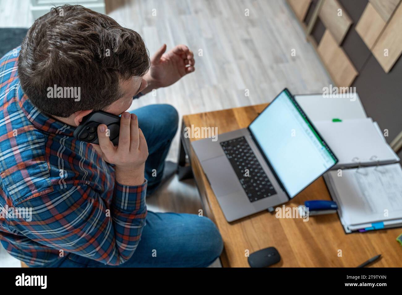Bayern, Deutschland - 24. November 2023: Ein junger Mann, der in seinem Heimbüro arbeitet. Geschäftsmann am Telefon mit seinem Smartphone *** ein junger Mann bei der Büroarbeit im Homeoffice. Geschäftsmann telefoniert mit dem Smartphone Credit: Imago/Alamy Live News Stockfoto