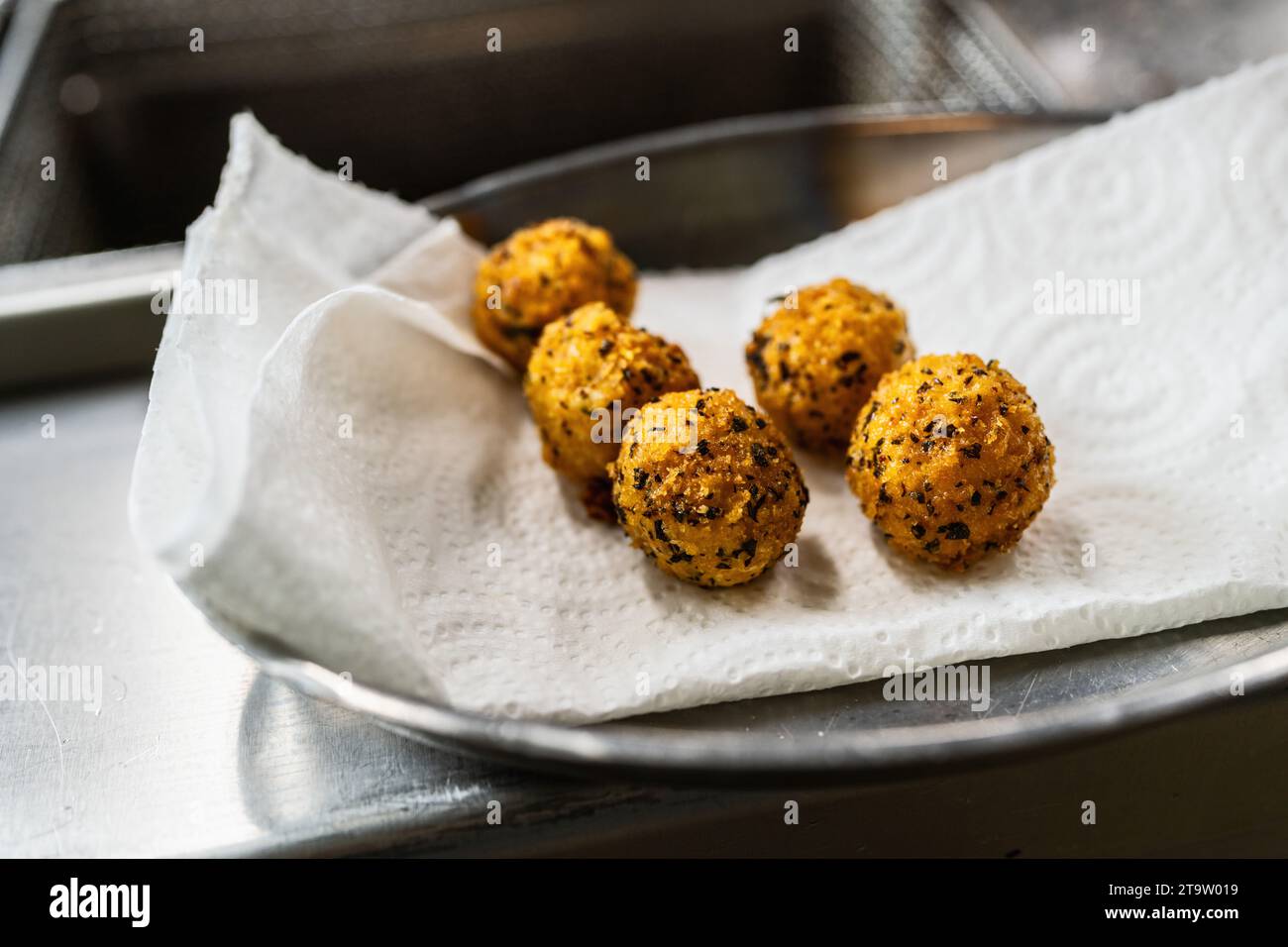 Luxuriöse Vorspeise mit gebratenen Kartoffelbällchen mit Kräutern in der Küche eines Restaurants. Lebensmittelfotografie Konzeptbild Stockfoto