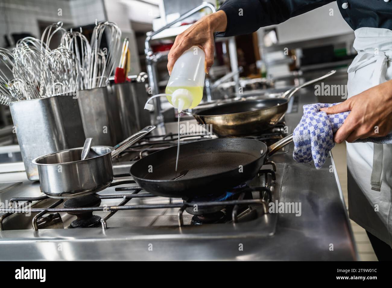 Kochen Sie Öl in eine beheizte Pfanne in einem Restaurant. Bild des Kochkonzepts des Luxushotels. Stockfoto
