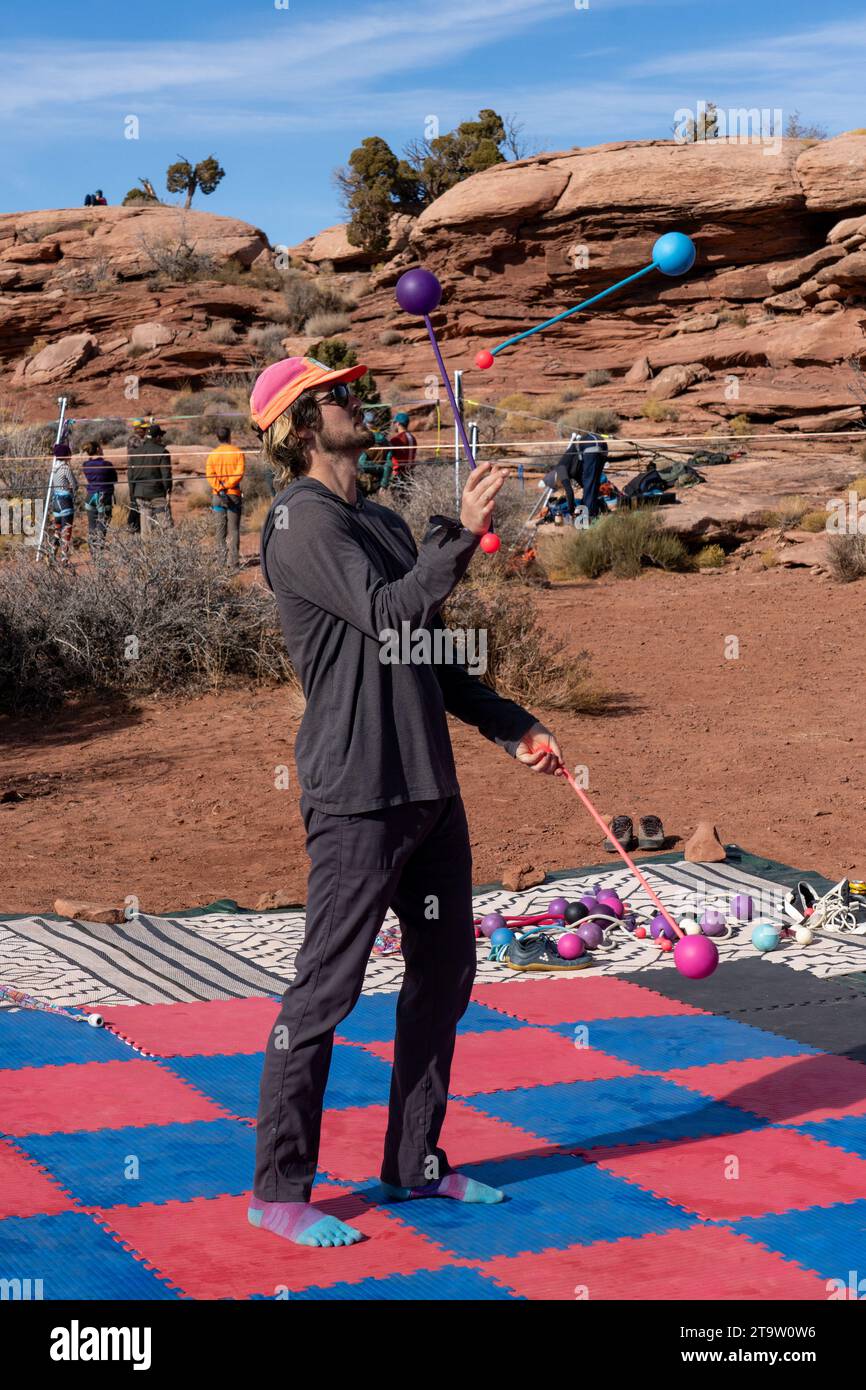 Ein Teilnehmer des GGBY Highlining Festivals übt sein Jonglieren, während er nicht durch die Highlines geht. Moab, Utah. Stockfoto