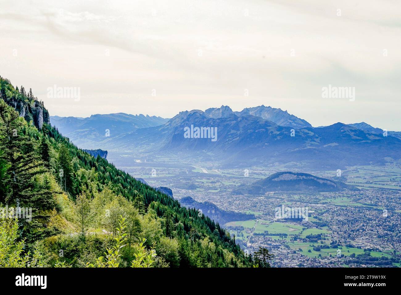 Die Landschaft entfaltet sich zu einem weiten Panorama, mit Tälern darunter und einem klaren, weiten Himmel darüber. Stockfoto