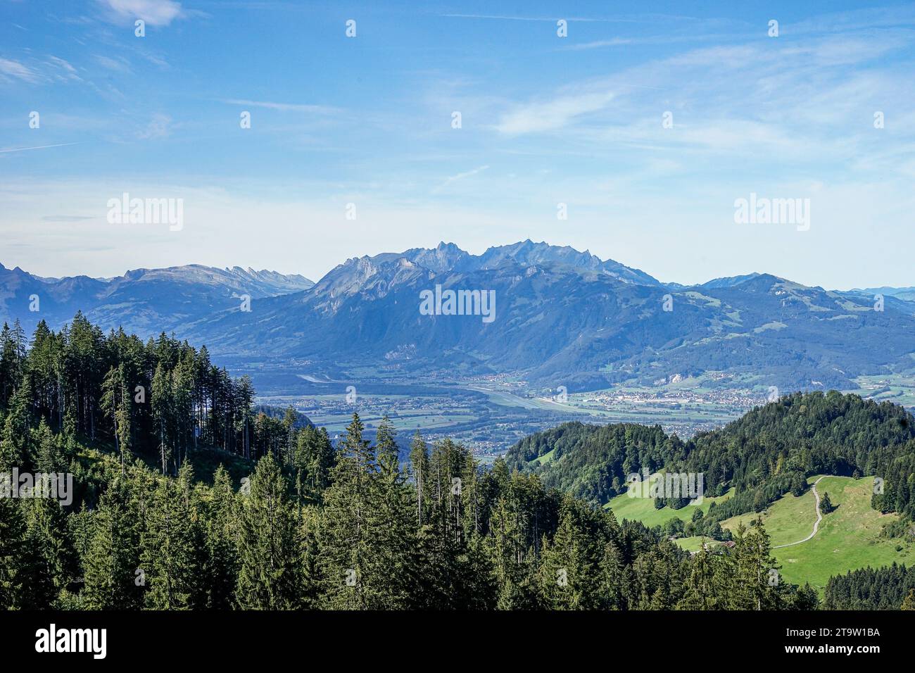 Hoch aufragende Gipfel erstrecken sich über den Horizont und ihre zerklüfteten Konturen werden von einem sanften Dunst gemildert. Stockfoto