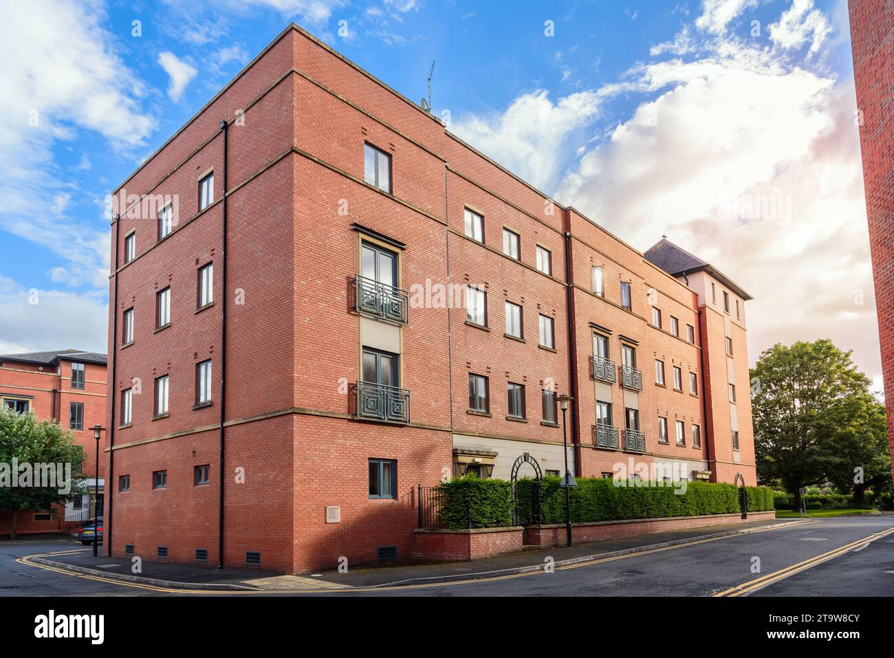 Backsteingebäude an einer Straße in einem vorstädtischen Wohnviertel bei Sonnenuntergang im Sommer Stockfoto