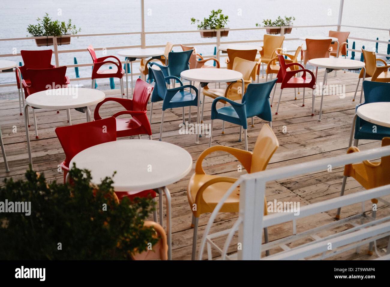 Farbenfrohe Stühle auf leerer Restaurantterrasse Stockfoto