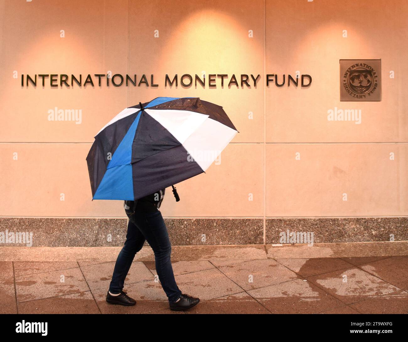 Washington, DC - 4. Juni 2018: Fußgänger mit einem Schirm in der Nähe des Internationalen Währungsfonds, IMF-Hauptquartier 2 (HQ2) in DC. Stockfoto