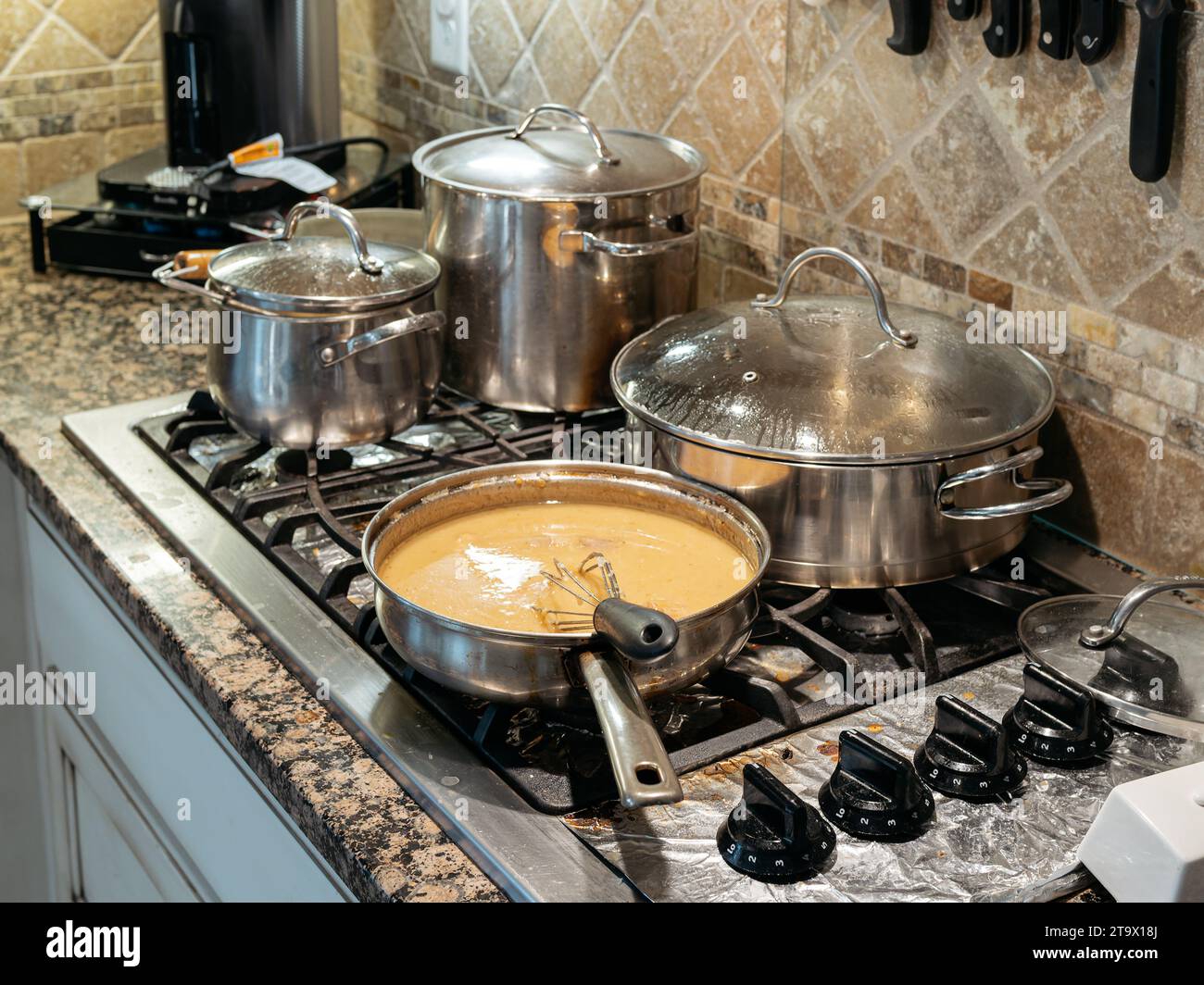 Töpfe und Pfannen kochen auf einem Gasherd in einem familiären Wohnhaus oder zu Hause. Stockfoto
