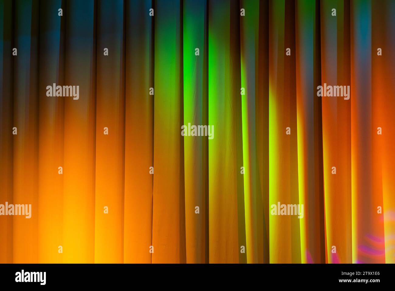 Geschlossener weißer wellenförmiger Vorhang mit bunten Spots, Hintergrundfotostruktur Stockfoto