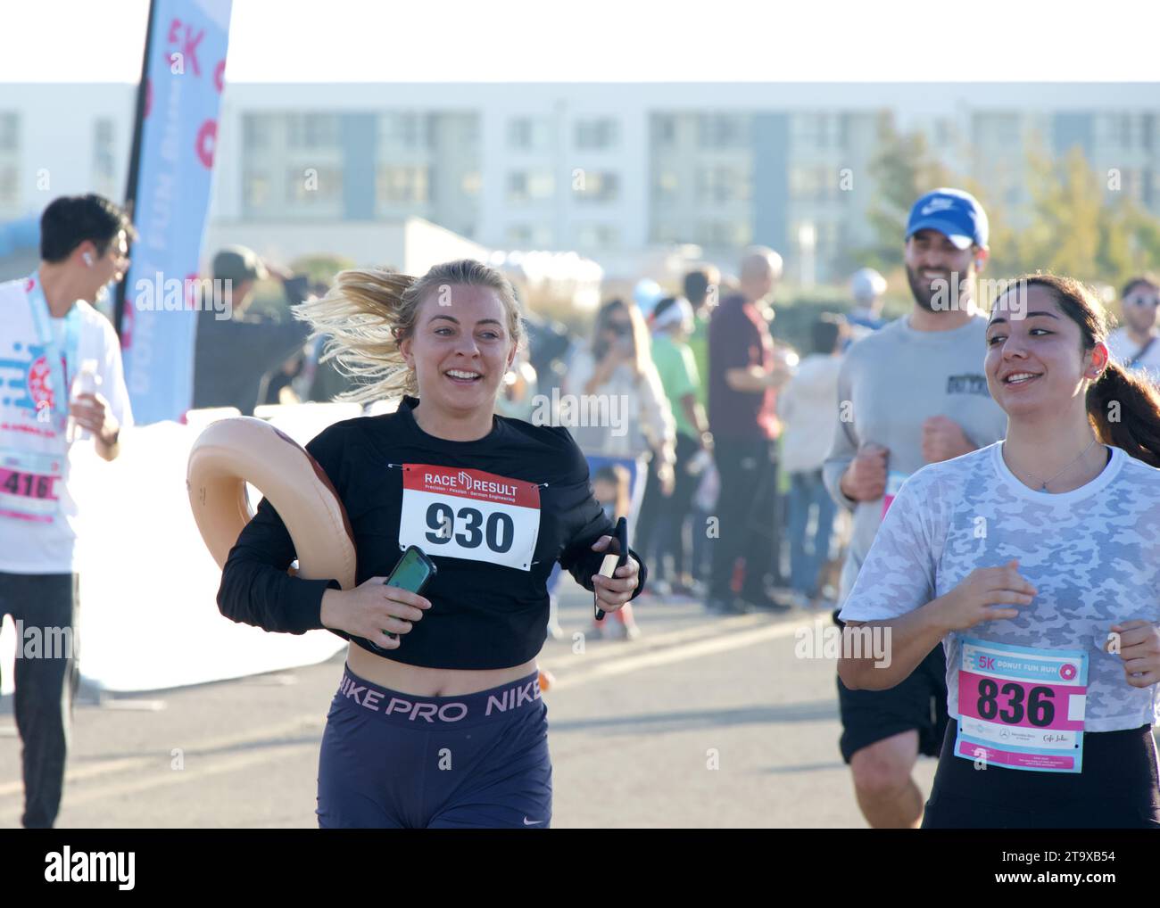Alameda, KALIFORNIEN - 21. Oktober 2023: Teilnehmer am ersten jährlichen Donut Fun Run. Ein 5-km-Rennen mit Donut-Thema an der Seaplane Lagoon Promenade von Alameda Point. Stockfoto