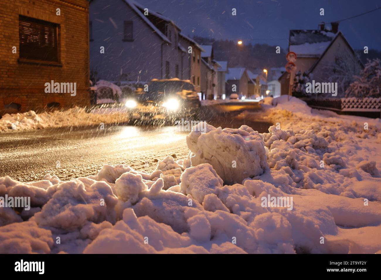 Niedernhausen, Deutschland. November 2023. Ein Auto fährt mit Gehgeschwindigkeit über eine freigelegte Straße. Schnee und vereiste Straßen haben in Teilen Deutschlands zu chaotischen Bedingungen geführt. Hessen ist besonders betroffen. Quelle: Jörg Halisch/dpa/Alamy Live News Stockfoto