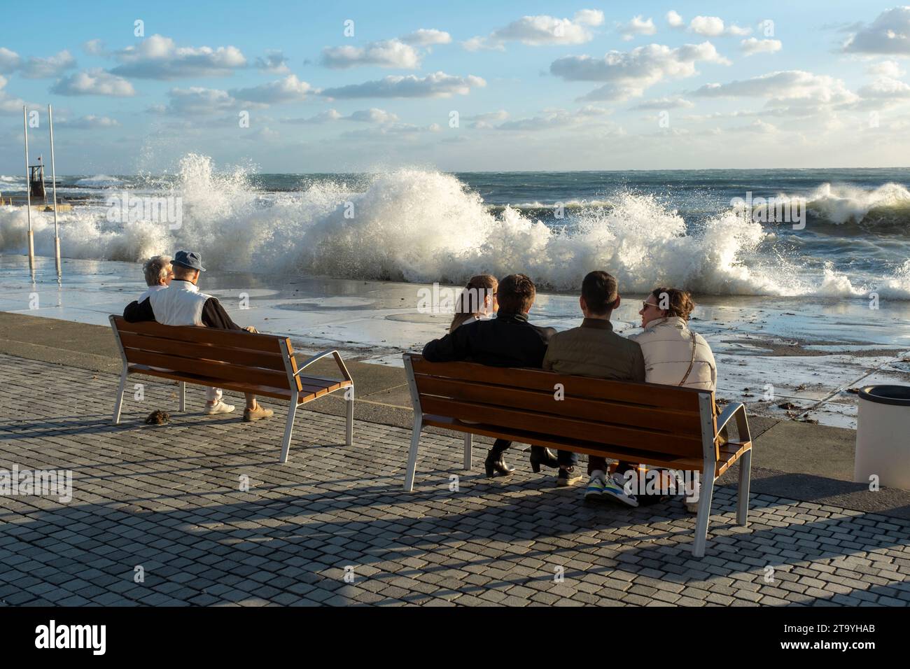 Touristen beobachten, wie Wellen über die Küste in Paphos krachen, Stockfoto