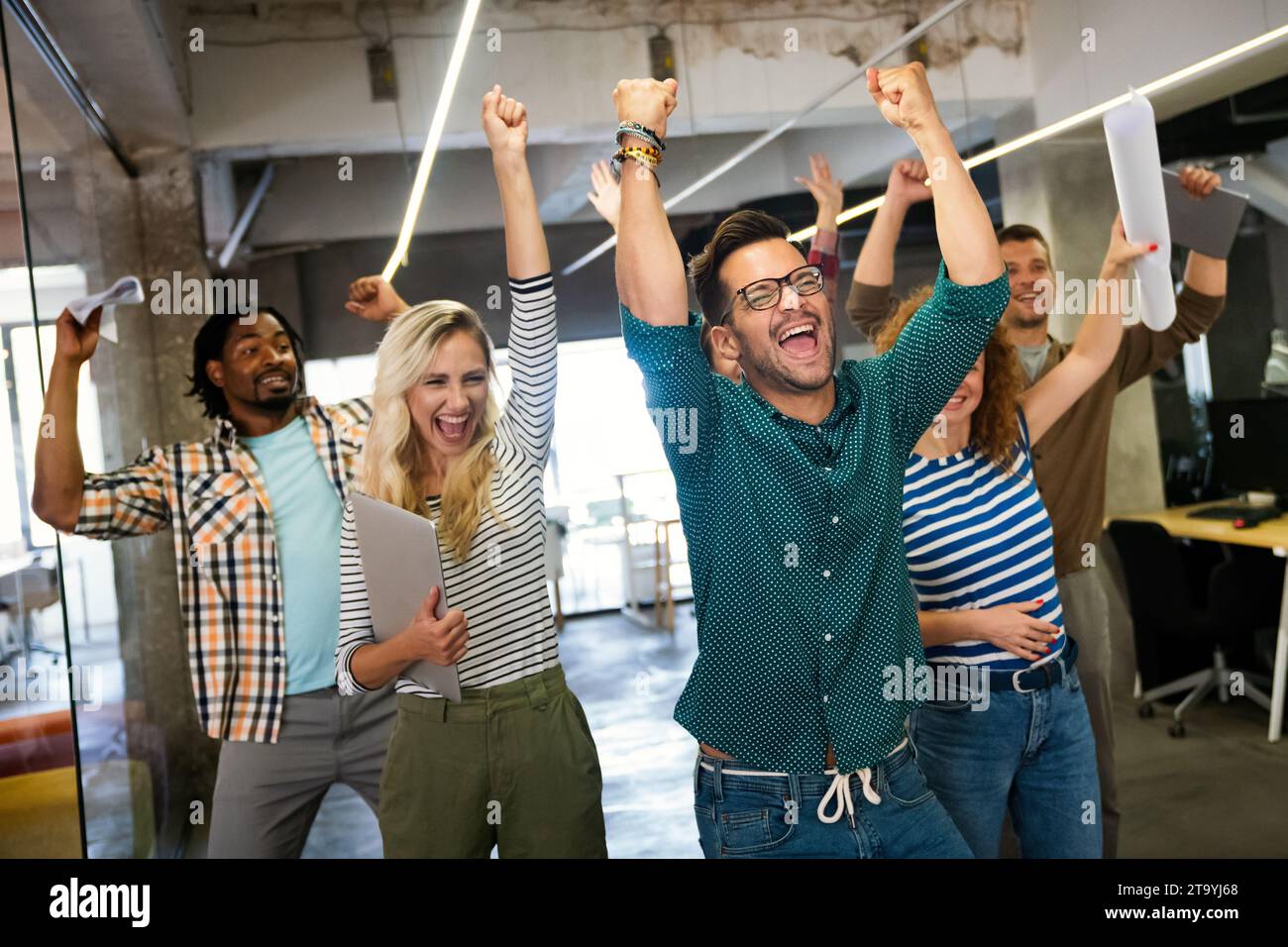 Glückliches Team verschiedener Mitarbeiter, das Erfolg und Geschäftserfolg feiert Stockfoto