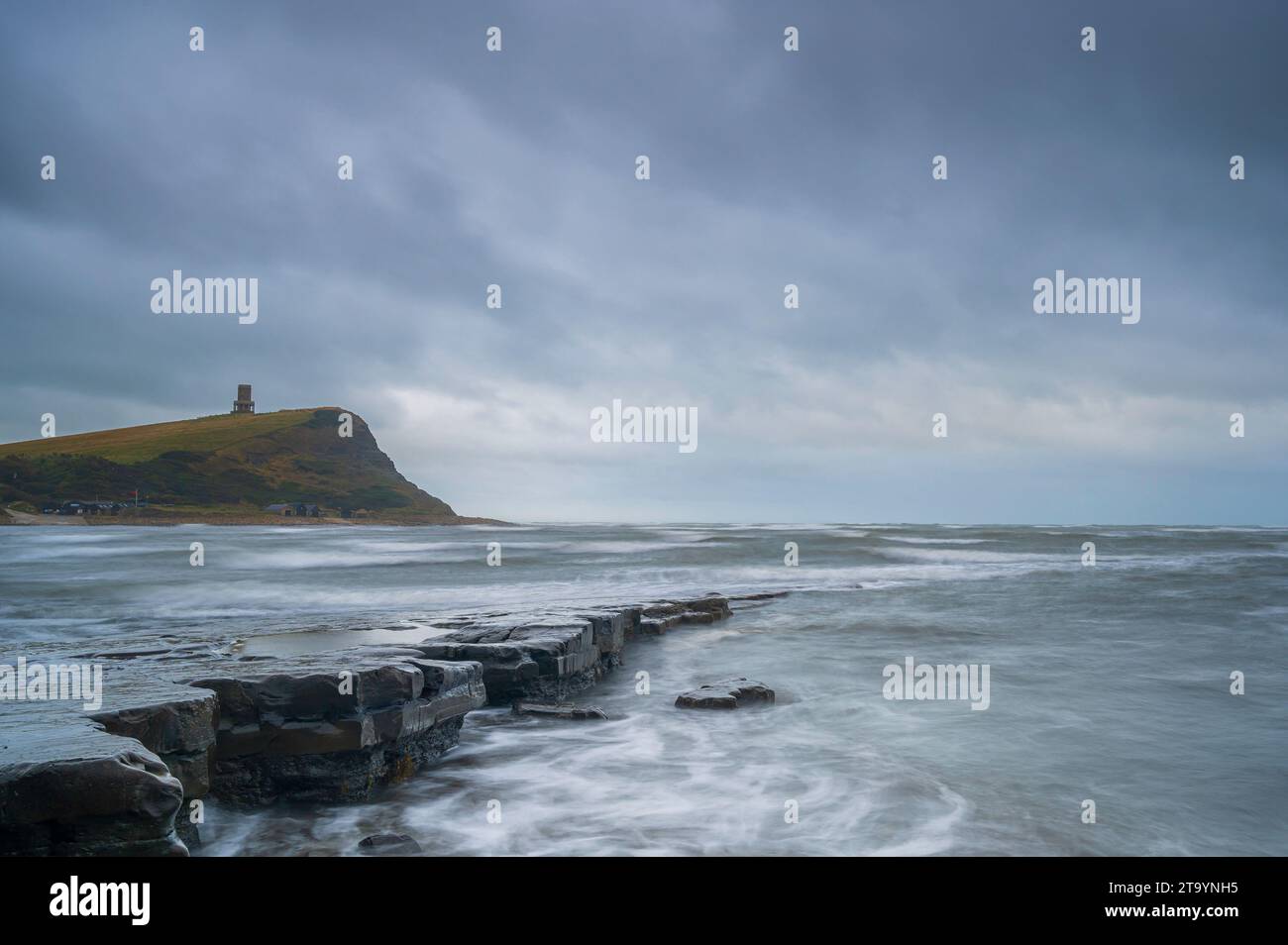 Verblassendes Licht über dem felsigen Strand der Kimmeridge Bay an der Südküste Englands an einem bewölkten Tag. Der Clavell Tower ist auf dem Vorgewende zu sehen. Stockfoto