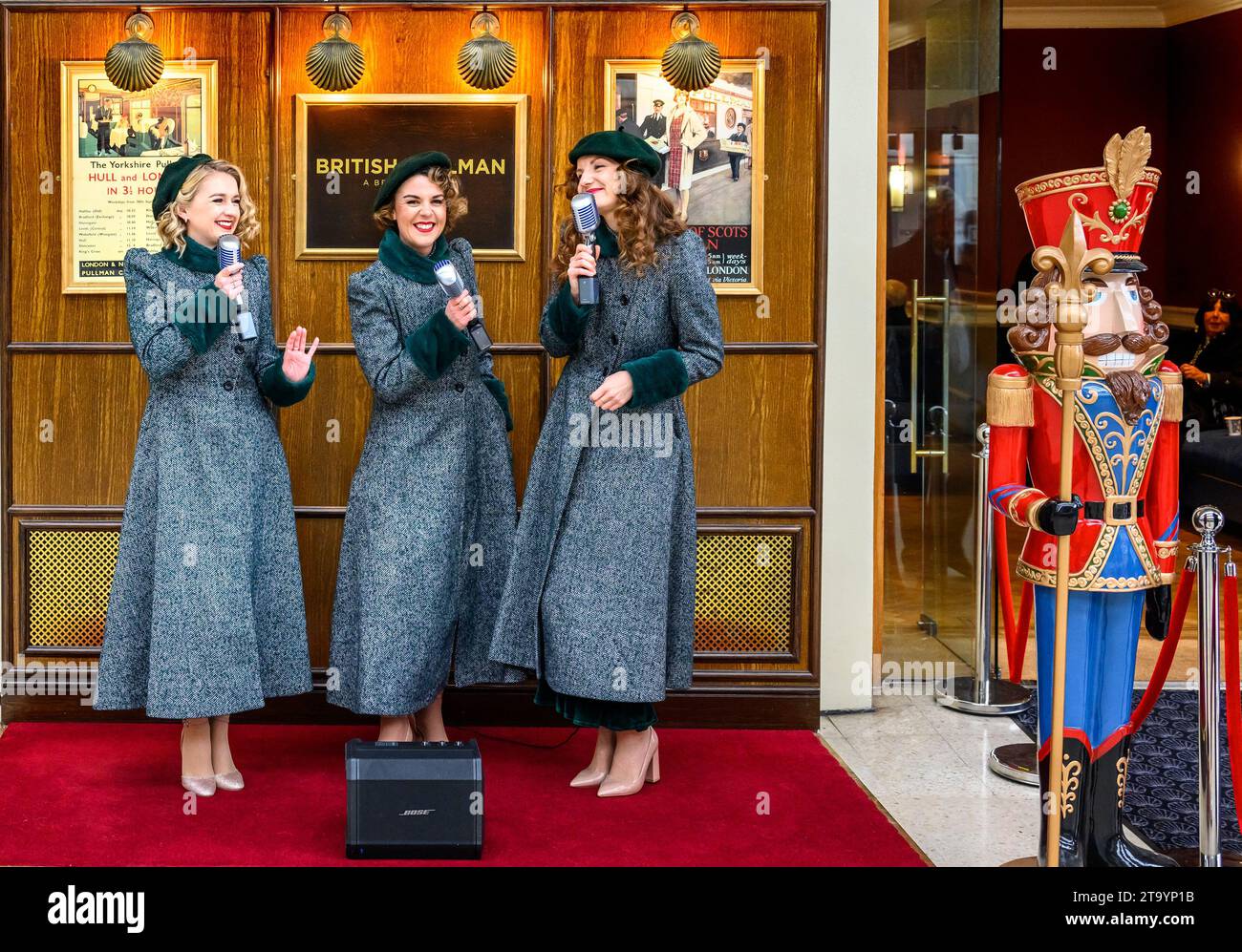 London, Großbritannien. Enge Harmonie Singers begrüßen Passagiere für den Orient Express auf Bahnsteig 1 am Bahnhof Victoria. November 2023 Stockfoto