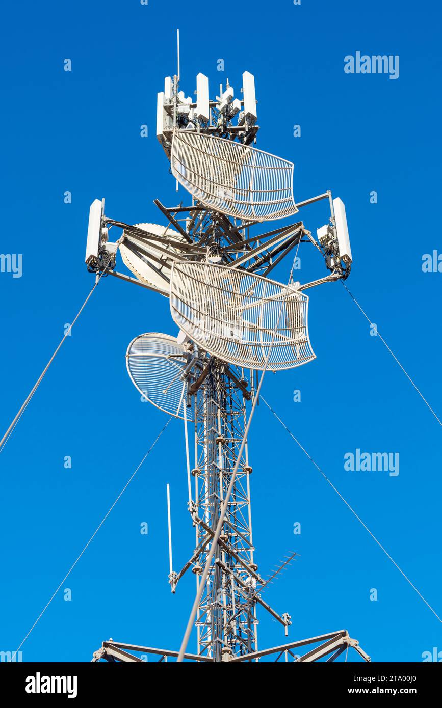 Der große Satellit- und Telekommunikationsturm im Yulara Ayers Rock Resort wird von großen Kabelanschlüssen unterstützt und ist eine wichtige Verbindung zur Außenwelt Stockfoto