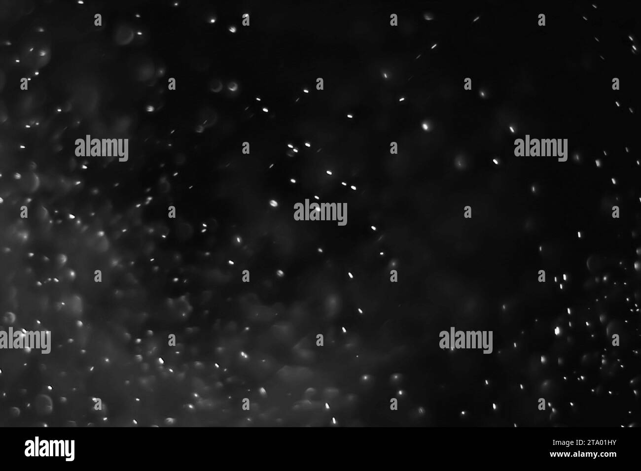 Abstrakte Staubpartikel auf dunklem Hintergrund mit Lichtfleck Stockfoto