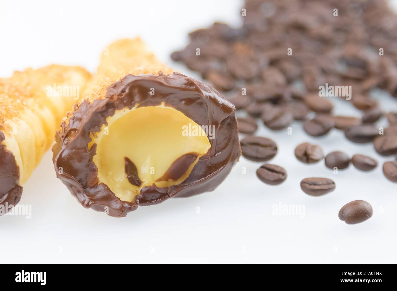 Köstliches sizilianisches Cannolo Cannellino süß mit Gebäck Haselnussschokolade und Gebäck Creme in der Nähe von Kaffeebohnen, italienisches Blätterteig auf weißem Hintergrund, Ernährungs- und Diätkonzept Stockfoto