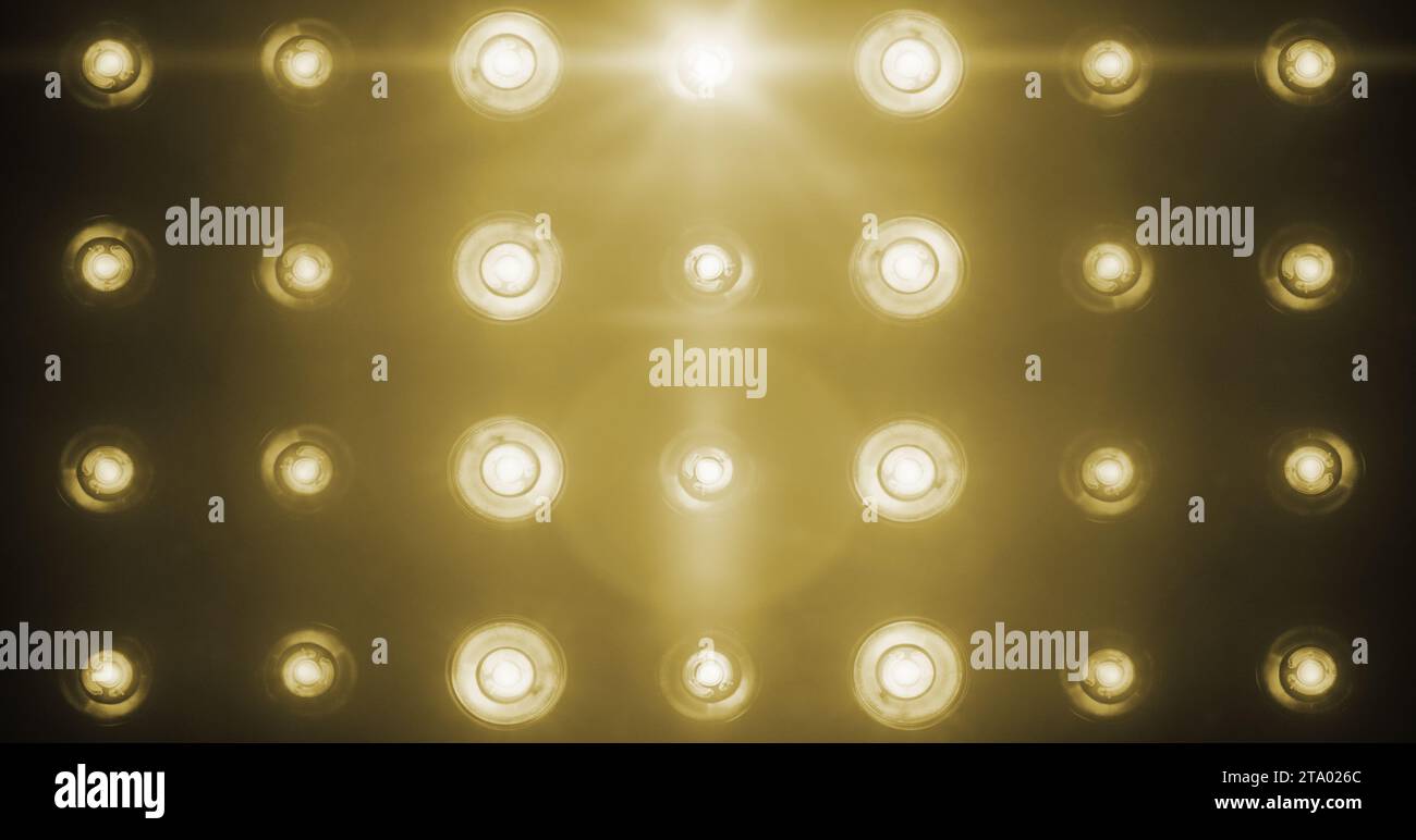 Blinkende goldene Bühnenlichter Unterhaltung, Spotlight-Projektoren im Dunkeln, goldene warme weiche Spotlight-Strike auf schwarzem Hintergrund Stockfoto