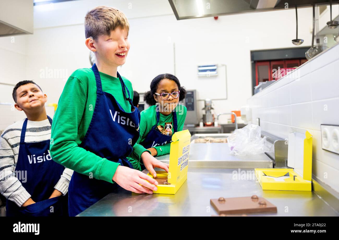 Rotterdam, Niederlande. November 2023. ROTTERDAM: Die Schüler machen in einem Kochzimmer unter der Leitung eines Kochlehrers ihren eigenen Braille-Schokoladenbrief. ANP IRIS VAN DEN BROEK niederlande Out - belgien Out Credit: ANP/Alamy Live News Stockfoto