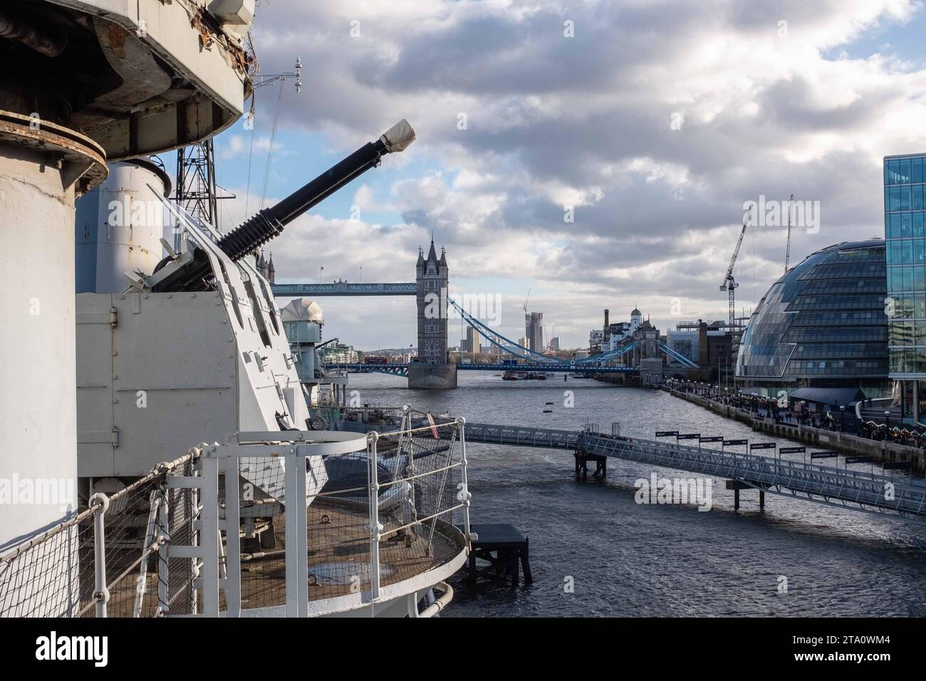 Blick auf die Tower Bridge, London vom Deck der IWM HMS Belfast mit Bofors-Kanonen im Vordergrund Stockfoto