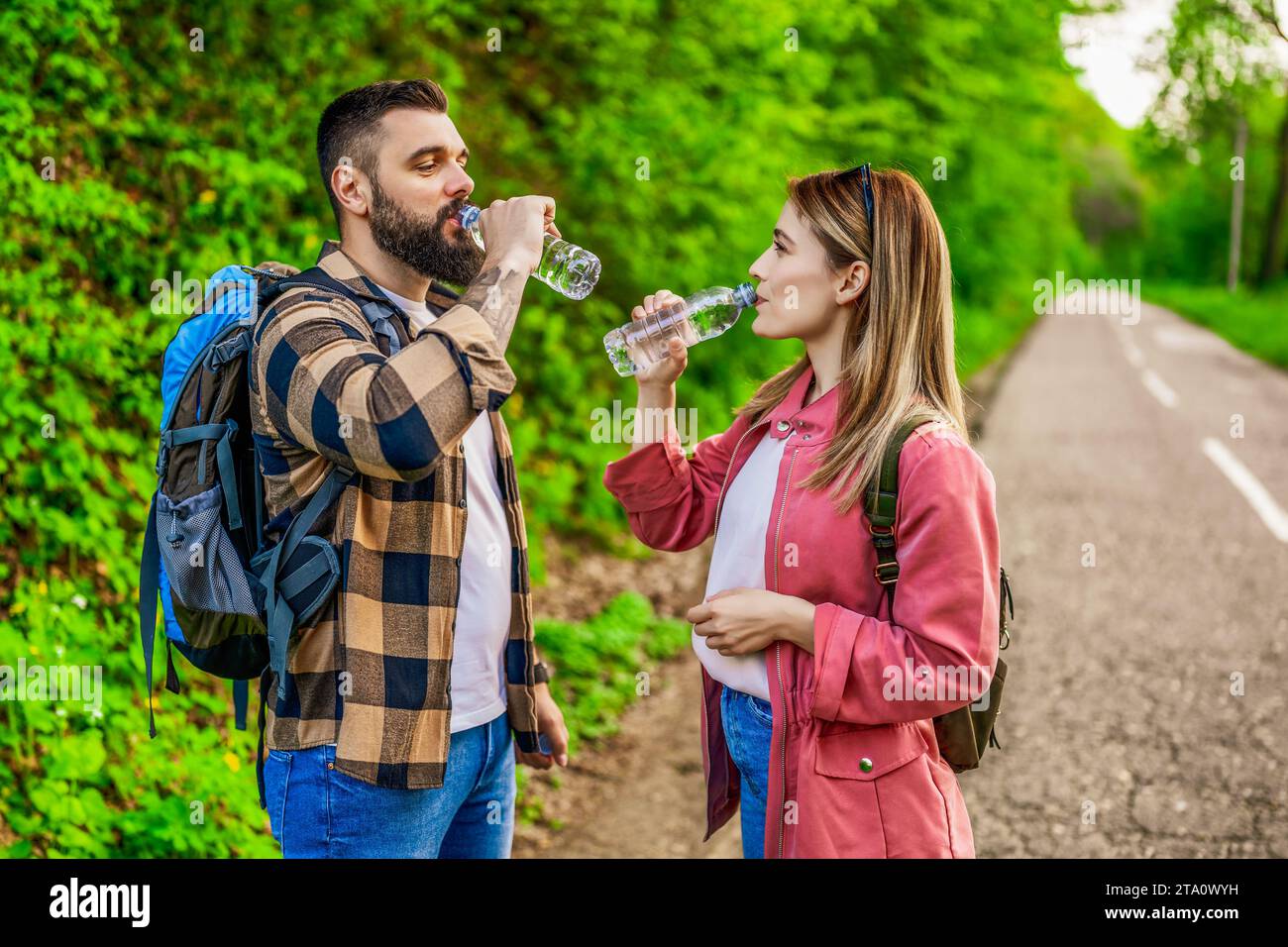 Glückliches Paar, das in der Natur wandert und Wasser trinkt. Ein Paar genießt seinen Urlaub. Stockfoto