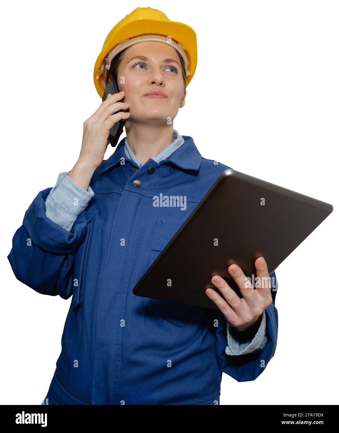 Isolierte lächelnde Ingenieurin in gelbem Helm und blauer Uniform mit Telefon und digitalem Tablet. Stockfoto