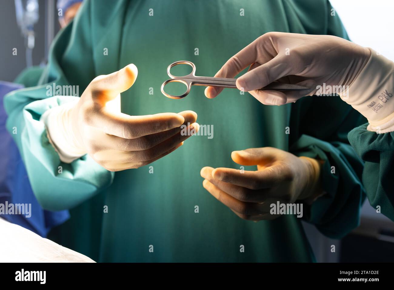 Hände diverser männlicher und weiblicher Chirurgen mit chirurgischem Werkzeug im Krankenhausoperationssaal Stockfoto