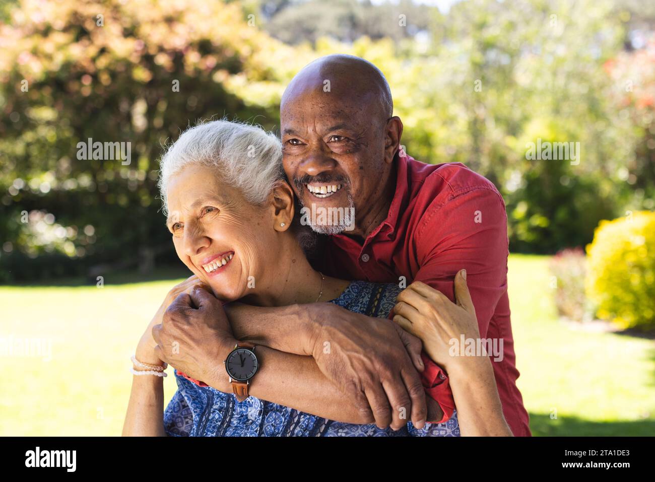 Glückliches, vielseitiges Seniorenpaar, das sich im sonnigen Garten umgibt. Lebensstil, Ruhestand, Seniorenleben, Natur, Zweisamkeit und häusliches Leben, unverändert. Stockfoto