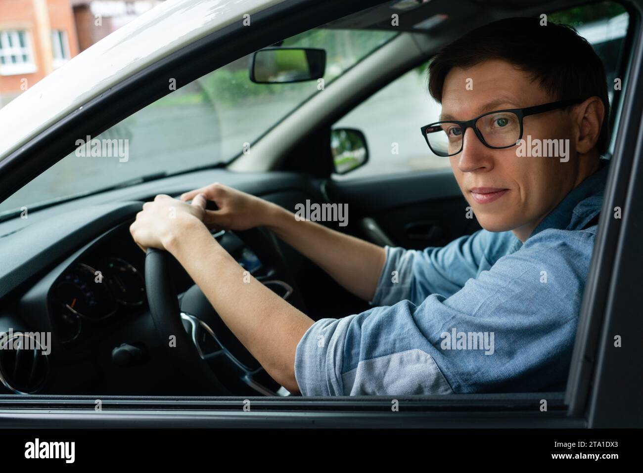 Der männliche Fahrer sitzt im Auto. Stockfoto
