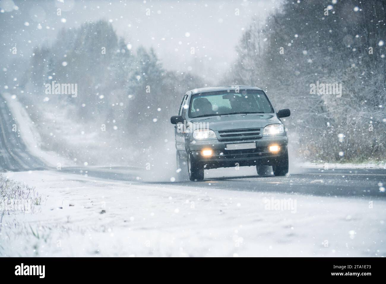 Das Auto fährt auf einer Winterstraße in einem Schneesturm. Stockfoto