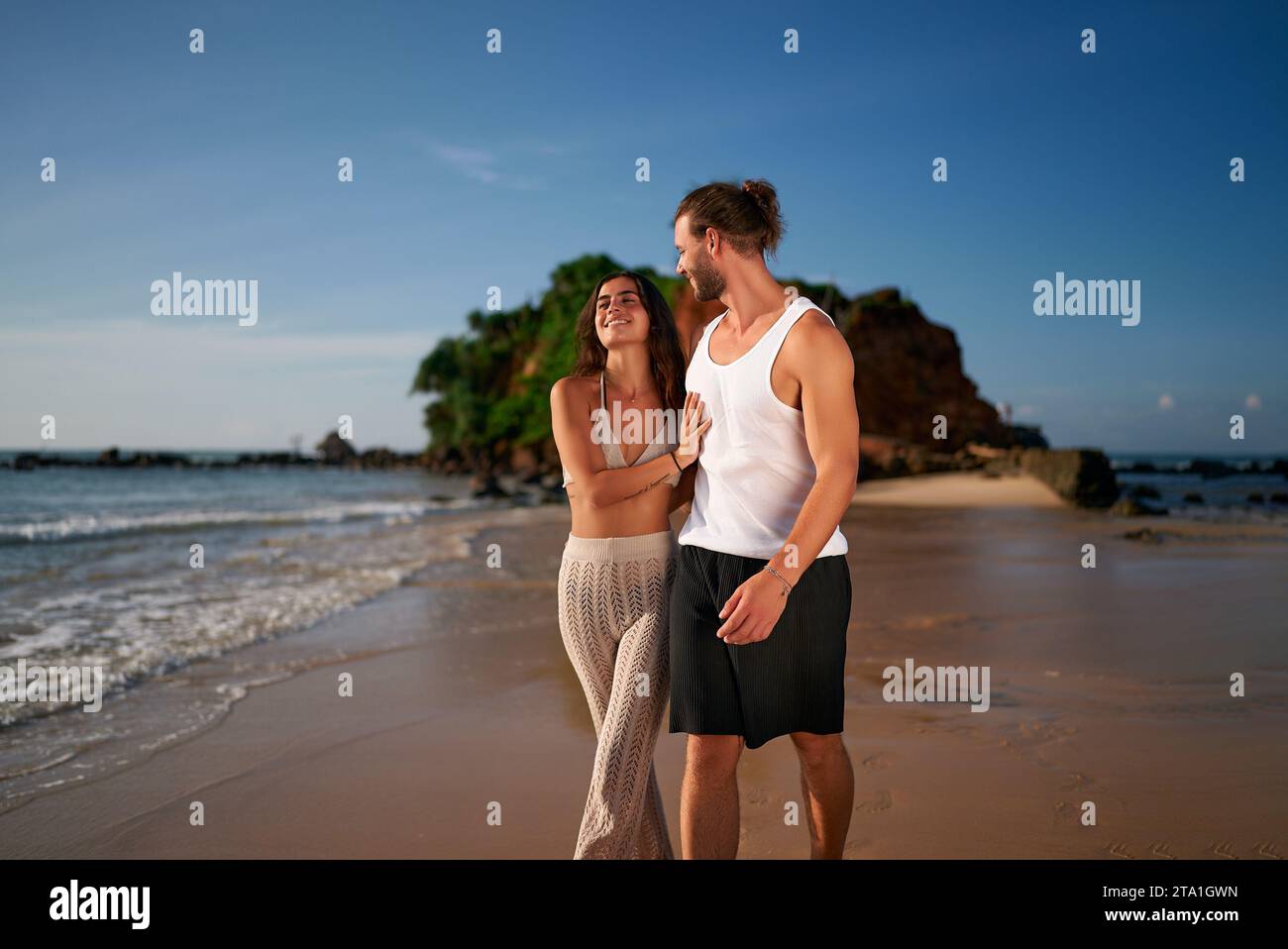 Erwachsene Paare genießen Sonnenuntergang am Strand ohne Kinder. Reisende laufen barfuß, entspannen sich auf dem Meer. Kinderfreies Urlaubskonzept, romantische Freizeit. Mann, Frau Stockfoto