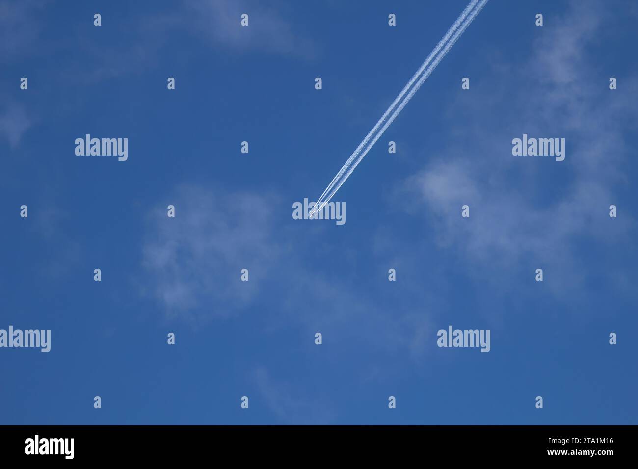 Jet-Flugzeuge fliegen in großer Höhe vor dem Hintergrund eines klaren blauen Himmels. Flugzeug mit Kondensationsspur auf Wolken und Himmel. Ansicht des Flugplans Stockfoto
