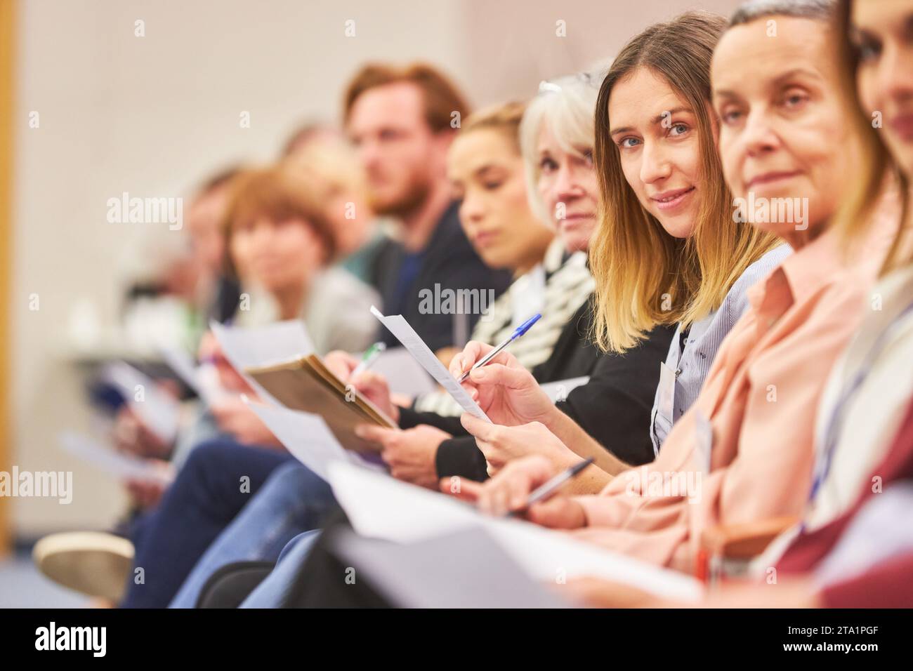 Porträt von männlichen und weiblichen Fachleuten, die im Publikum auf einer Geschäftskonferenz im Kongresszentrum sitzen Stockfoto