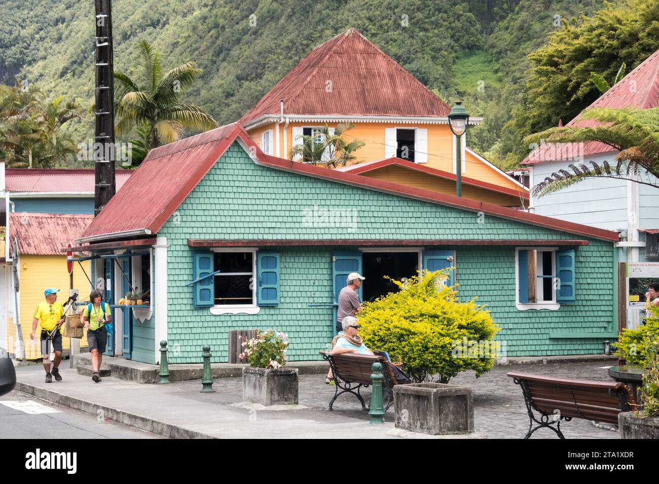 Grüne Schindelhandlung im Dorf Hell-Bourg, Insel Réunion, Frankreich. Grüne Türen mit orangefarbener Fassade. Stockfoto