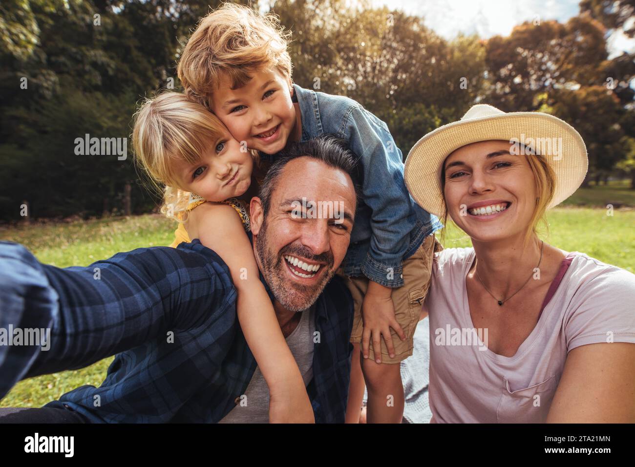 Freundliche Familie selfie machen. Eltern Spaß mit Ihren Kindern draußen im Park. Nette Familie mit Picknick. Stockfoto