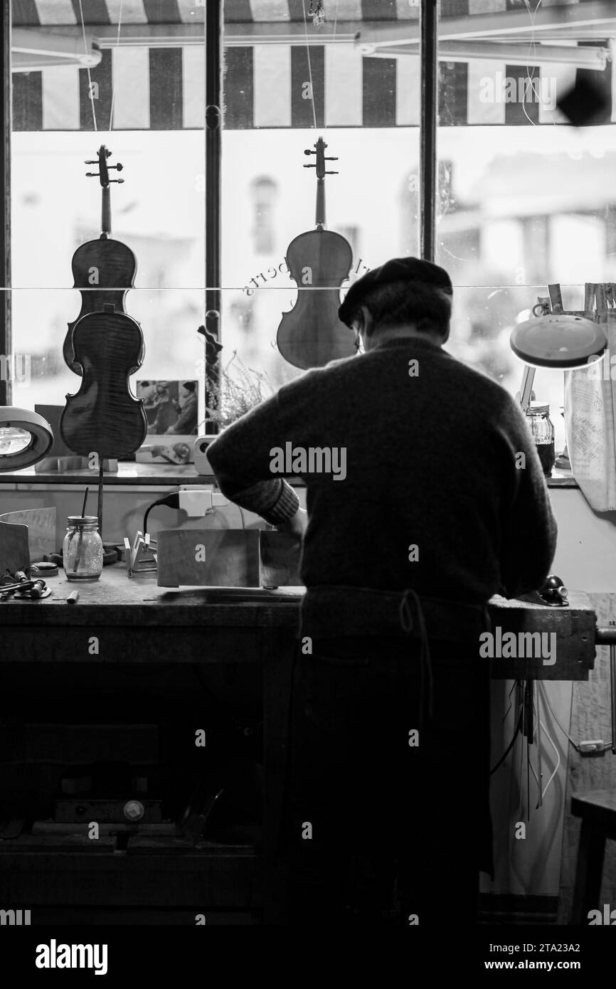 Erfahrener Geigenbauer schnitzt in der Werkstatt Cremona Italien, selektiver Fokus, Bokeh Stockfoto
