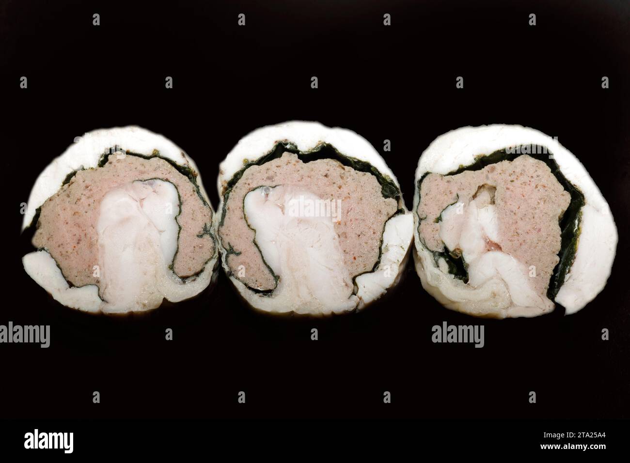 Als kalte Vorspeise, drei Scheiben französisches Hühnchen, gefüllt mit Spinat und Rinderfarce, Lebensmittelfotografie mit schwarzem Hintergrund Stockfoto