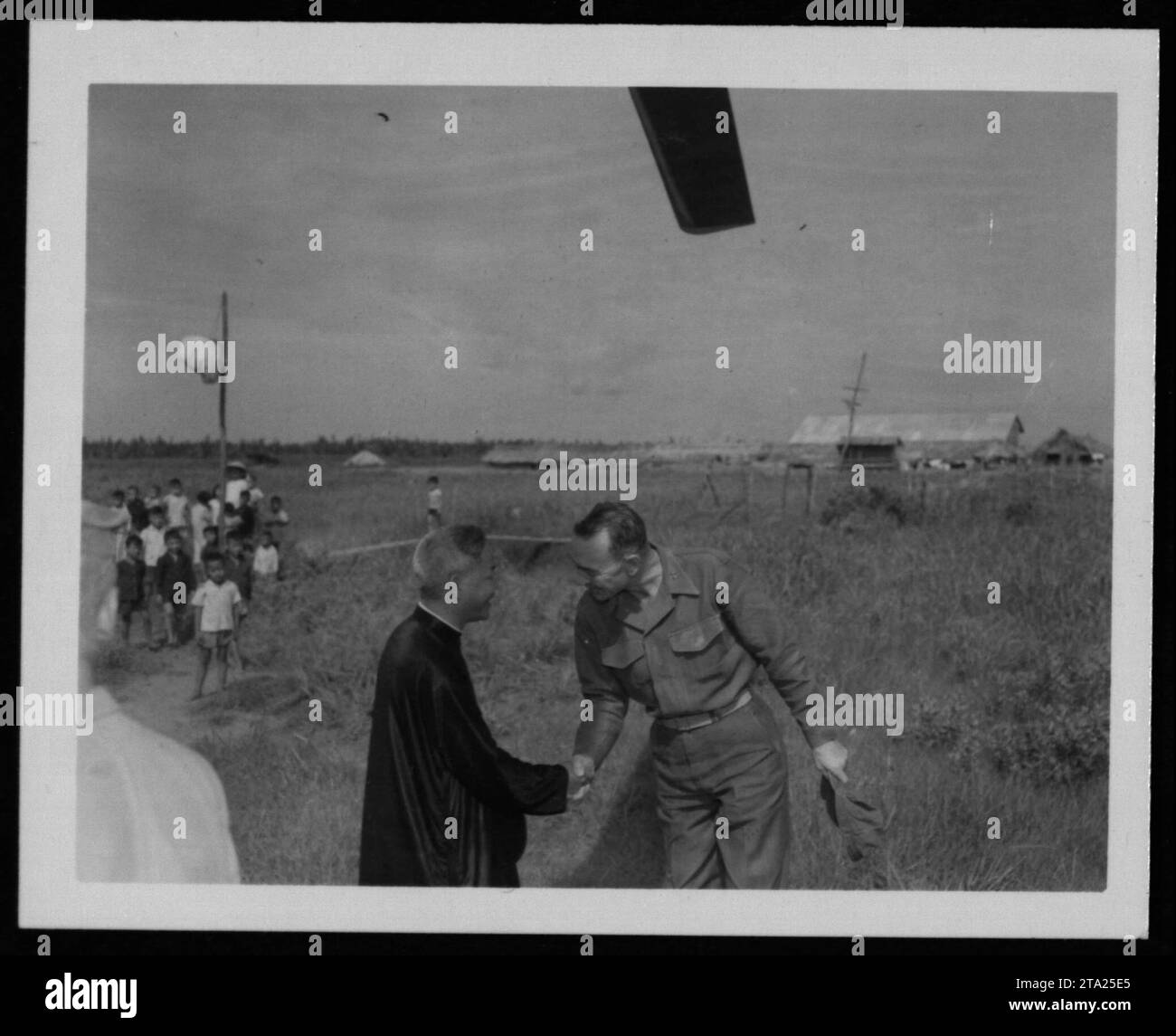 Amerikanischer Soldat, der während des Vietnamkriegs mit vietnamesischen Zivilisten interagiert. Das Bild erfasst die Interaktion zwischen Menschen und zeigt die Bemühungen, Beziehungen aufzubauen und lokale Gemeinschaften zu unterstützen. Dieses Foto wurde am 24. Juli 1962 aufgenommen, während der frühen Phasen der amerikanischen militärischen Beteiligung in Vietnam." Stockfoto