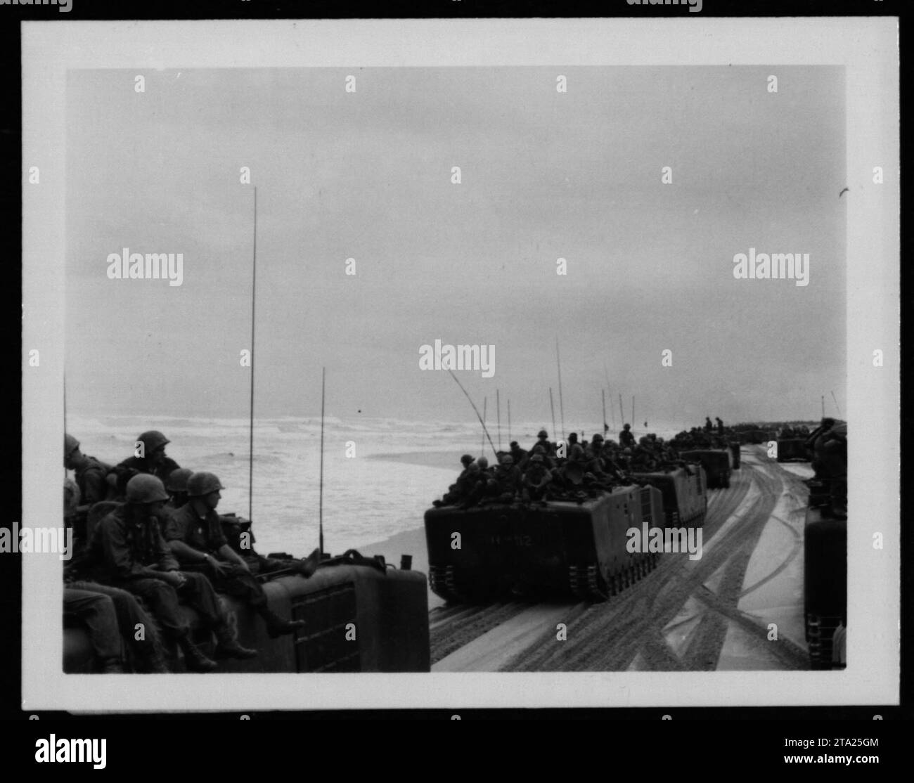 Amerikanische Soldaten in Kampfausrüstung stehen während des Krieges in einer ländlichen Gegend Vietnams Wache und demonstrieren Wachsamkeit und Einsatzbereitschaft. Stockfoto