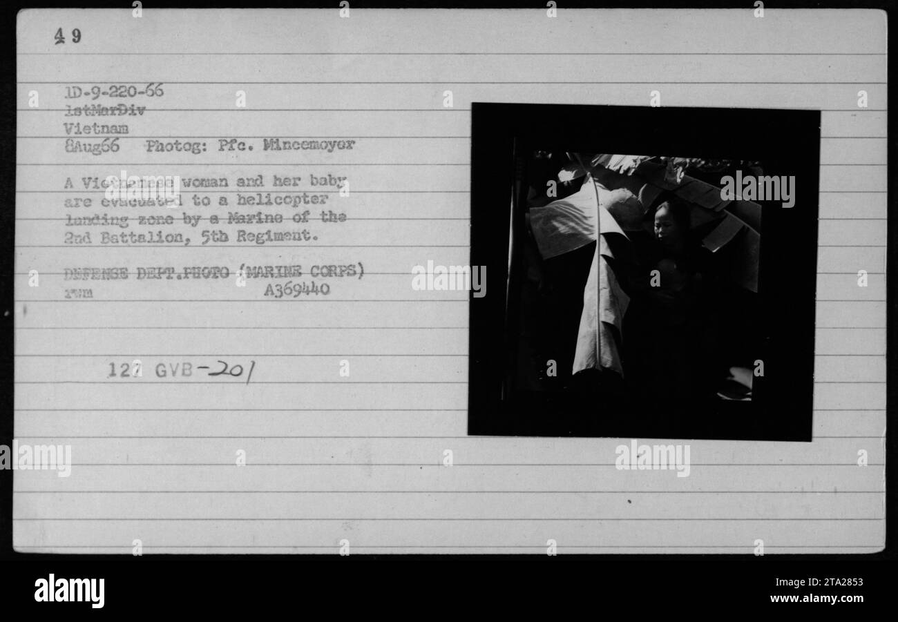 Eine vietnamesische Frau und ihr Baby wurden von einem Marine vom 2. Bataillon, 5. Regiment, zur Evakuierung während der Operation Liberty Bridge am 8. August 1966 in eine Hubschrauberlandezone begleitet. Das Foto dokumentiert zivile Evakuierungsmaßnahmen während des Vietnamkrieges. Stockfoto